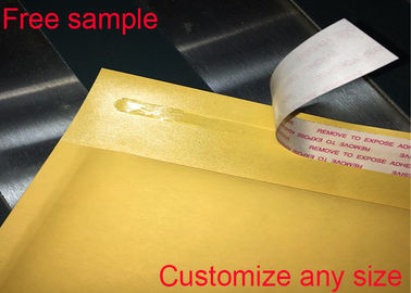 黄色いクラフト紙の郵送物は利用できる自己接着シールのロゴの印刷を囲む